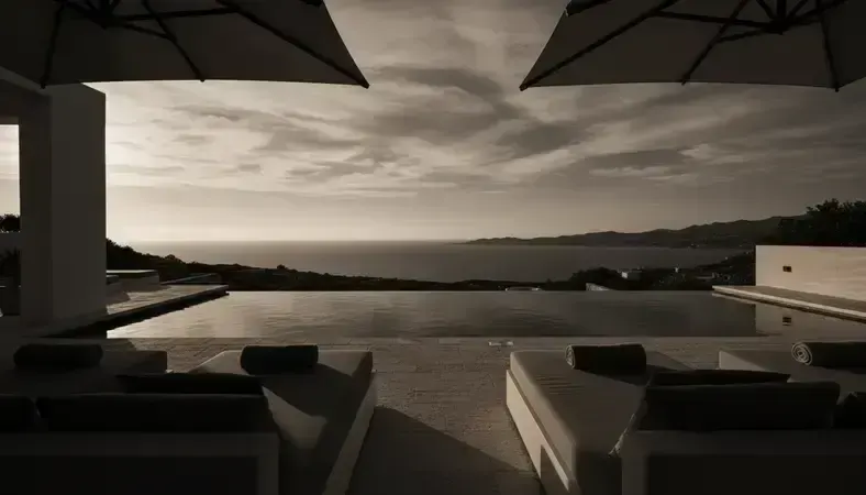 Luxurious infinity pool area of Ibiza villa with lounge areas and panoramic sea views during golden hour